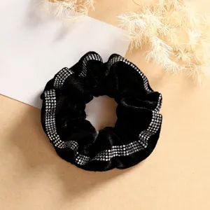 Close-up detail of black velvet hair scrunchie sparkling with exquisite rhinestones.