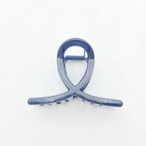 Minimalist dark blue hair claw clip, unique loop crossed design detail view for daily hair styling