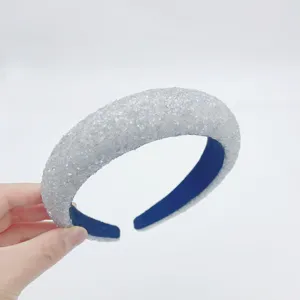 Detailed shot of a sparkly silver sequin padded headband with dark blue inner lining.