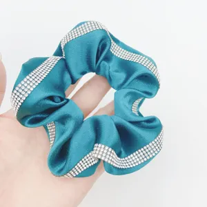 Elegant satin hair scrunchie with sparkling rhinestone trim, perfect for chic ponytails.