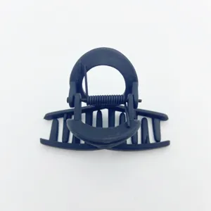 Close-up detail of the matte black hair claw clip, featuring a minimalist round top design.