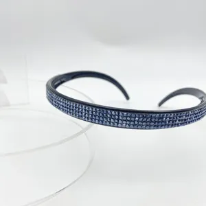 Detailed close-up shot of a sleek black hair hoop embedded with blue rhinestones.