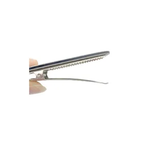Detail shot of metal duckbill hair clip side profile showing serrated grip structure.