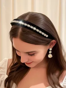 Detail view of black velvet rhinestone headband and crystal drop earrings worn by model.