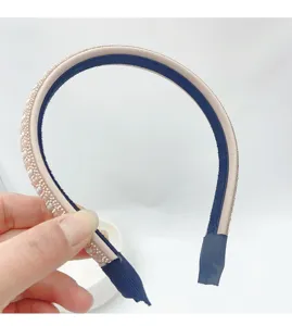 Detailed close-up of the rhinestone and pearl headband, showing fine material and texture.