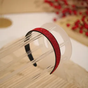 Close up of a sparkling red rhinestone headband displayed clearly. Perfect detail view of shiny crystals.