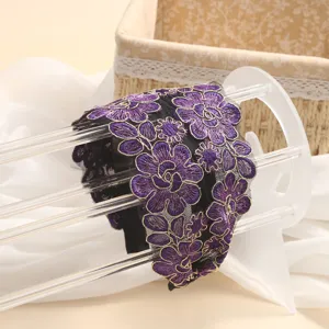 Detailed view of wide mesh headband featuring elegant purple floral embroidery design.