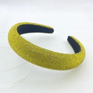 Closeup of the yellow rhinestone padded headband, showing sparkling crystals and sponge structure.
