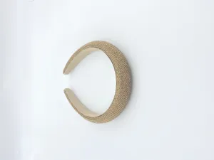 Closeup of a sparkling gold rhinestone padded headband, showing detailed crystal texture.