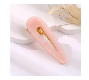 Close up detail of a cute pink acrylic hair clip with gold metal duckbill clasp, aesthetic.