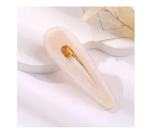 Close-up detail shot of marble acrylic teardrop hair clip with gold metal duckbill spring clasp.