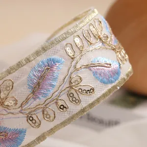 Exquisita diadema bordada a mano con hilos dorados, lentejuelas y diseño de plumas.