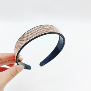 Elegant rhinestone headband, black plastic base sparkling with champagne crystals for women.