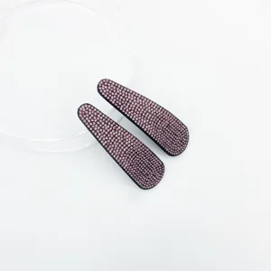 Close-up detail of sparkling pink rhinestone hair clips with dense crystal embellishments.