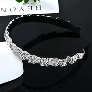 Close-up detail of luxury black rhinestone headband, sparkling crystal embellished surface.