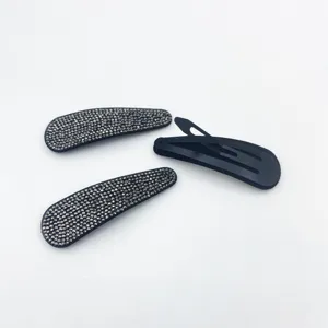 Rhinestone hair clip detail showing sparkling dark crystals and black metal snap back.