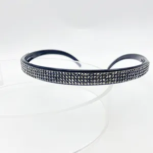 Detailed close-up of a stylish black rhinestone headband showing sparkling crystal details.