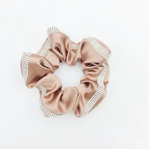 Satin hair scrunchie with sparkling rhinestone edges, elegant low ponytail accessory.