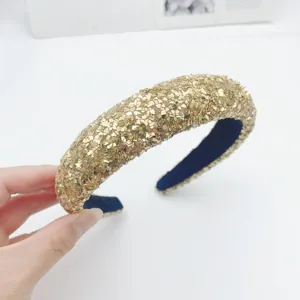 Gold sequin headband detail closeup, sparkly high skull top hair accessory design.