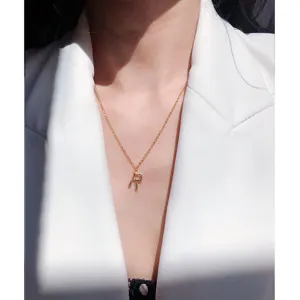 Primer plano muy detallado del elegante collar con colgante de letra chapado en oro.