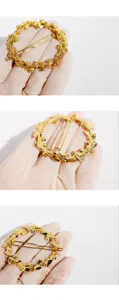 Gold floral wreath hairpin detail showing delicate rose relief and shiny metal finish.