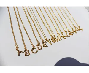 Collar con colgante de letra de bambú chapado en oro, vista detallada de cadena delicada.