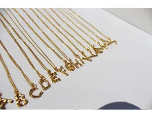 Primer plano de un collar con colgante de letra del alfabeto bañado en oro con diseño texturizado.
