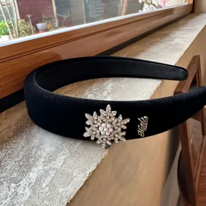 Black velvet headband detail featuring sparkling crystal snowflake and pearl ornament accessory.