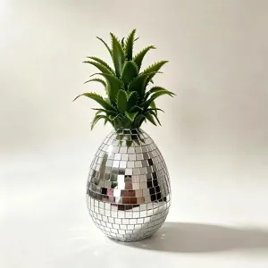 Détail d'ornement d'ananas disco argenté, carreaux de miroir réfléchissants et feuilles.
