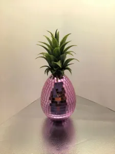 Vue de détail d'ananas miroir disco rose, décoration de fête de fruits en verre scintillant.