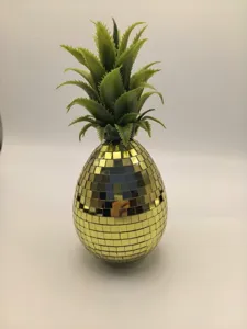 Détail d'ornement d'ananas miroir disco doré, décoration brillante pour maison et fête.