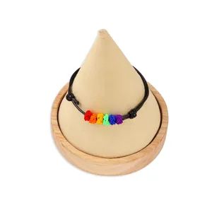 Bracciale intrecciato arcobaleno in stile bohémien con cordino nero e nodi colorati.