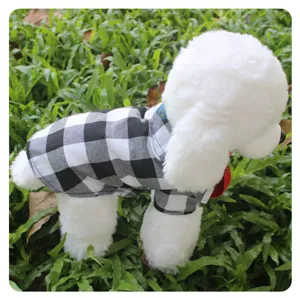 Closeup detail of a stylish black and white plaid pet shirt worn by a model dog on grass.