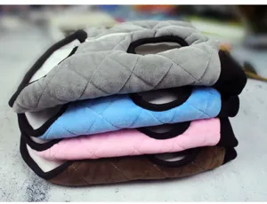 Close-up detail of soft quilted winter pet clothes neatly stacked in multiple vibrant colors.