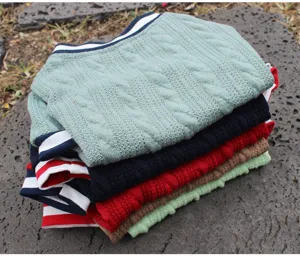 Nahaufnahme von bunten gestrickten Haustier Hundepullovern mit Zopfmuster und Rippstrickkragen.