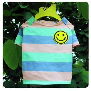 Gedetailleerd overzicht van kleurrijk gestreept huisdier-T-shirt met gele smiley-patch.