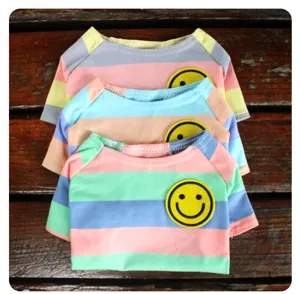 Gedetailleerd overzicht van kleurrijk gestreept huisdier t-shirt met gele smiley patch voor honden.