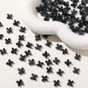 Detail shot of black acrylic 4-petal flower beads, perfect for DIY jewelry and crafts.