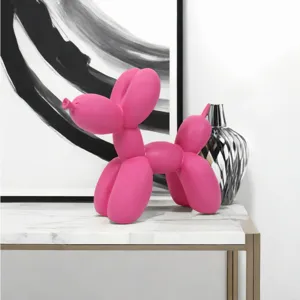 Primer plano de una escultura de perro globo de resina rosa, decoración de arte moderno para mesa.