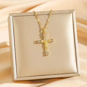 Close-up of a sparkling gold cubic zirconia cross pendant necklace detail on a chic box.