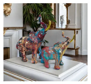 Detailed close-up of colorful abstract graffiti resin elephant figurines with golden tusks.