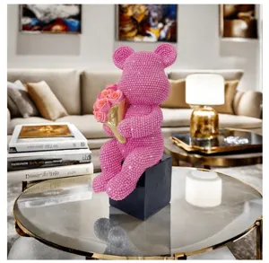 Sparkling pink rhinestone teddy bear holding rose bouquet ornament for modern luxury home decor.