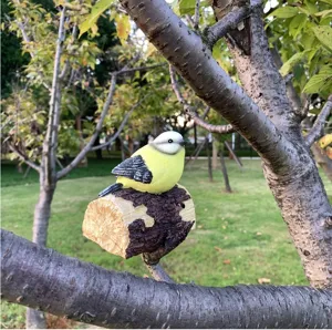Detailaufnahme einer Vogel-Harzfigur am Ast, Outdoor Garten dekoratives Deko-Ornament.