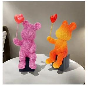 Resin bear sculpture detail showing sparkling rhinestone surface and cute heart balloon design.