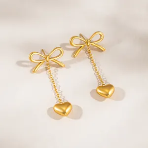 Detailed close-up of stainless steel bow heart tassel earrings, stylish and elegant design.