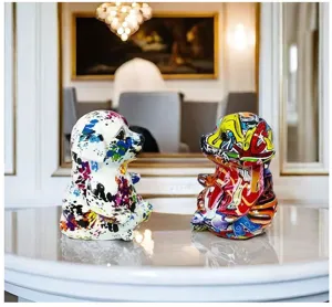 Primo piano dettagliato di statuette in resina di cane yoga graffiti colorato su un tavolo.