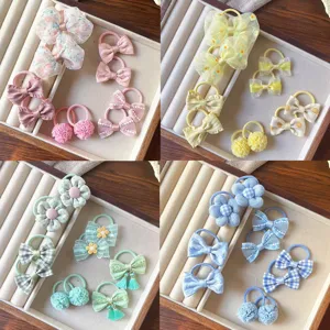 Vista dettagliata di simpatici elastici per capelli per bambini con fiocchi e fiori colorati.
