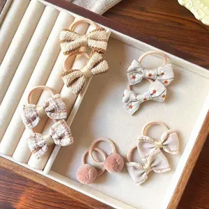 Primo piano dettagliato di elastici per capelli da bambini con fiocchi e morbidi pompon.