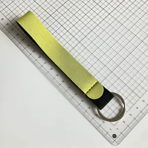 Detailed view of yellow and black wrist lanyard keychain made of neoprene material with ring.