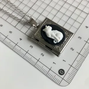 Vintage cameo cat book locket necklace, silver-tone metal pendant with cute relief cat design.